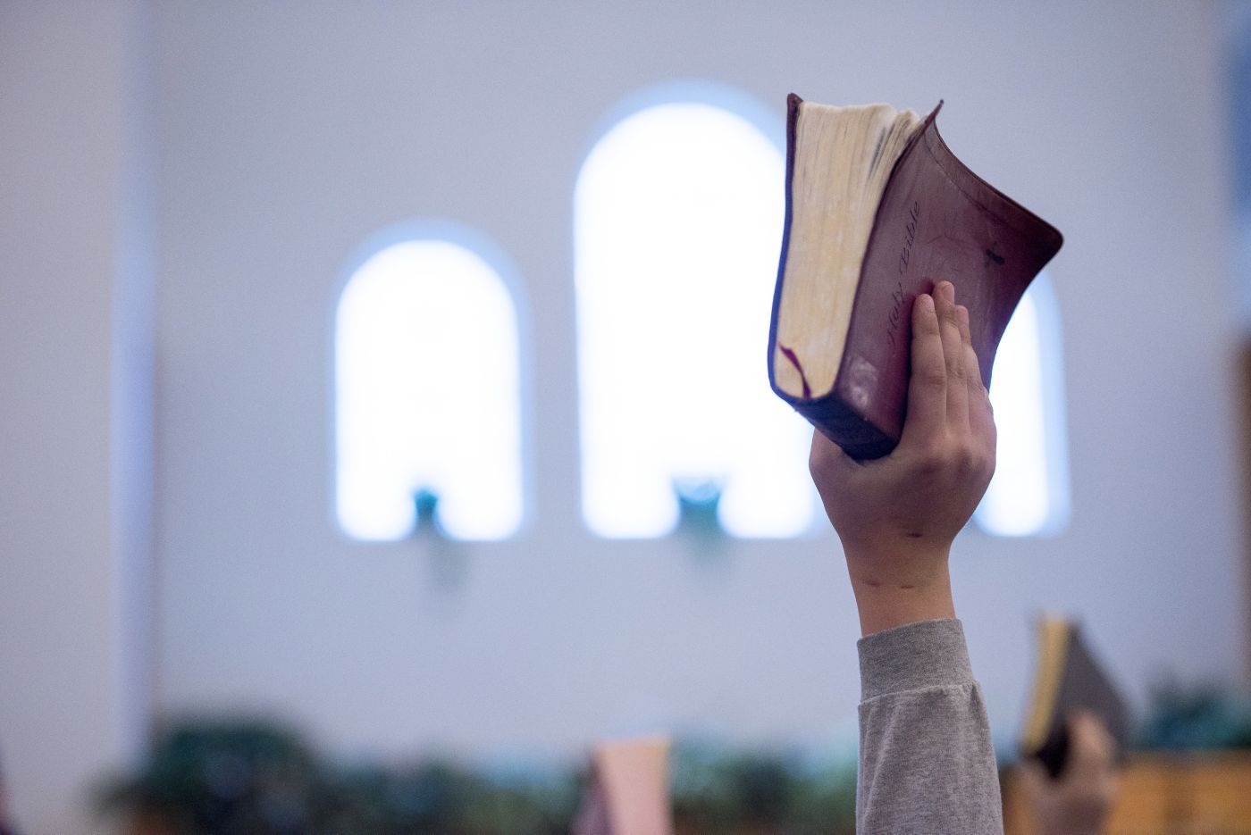 A worshipper holding up a Bible